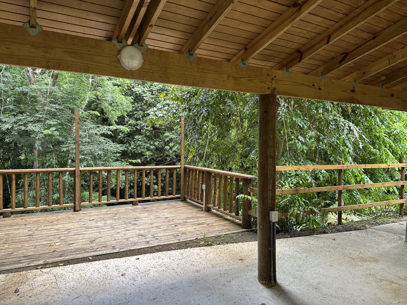 Covered deck at Batey Zumbador opening onto the surrounding rainforest