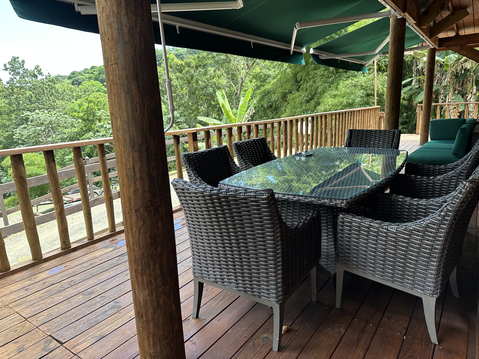 Covered deck dining area at Casa Bambú seating six, with rainforest views