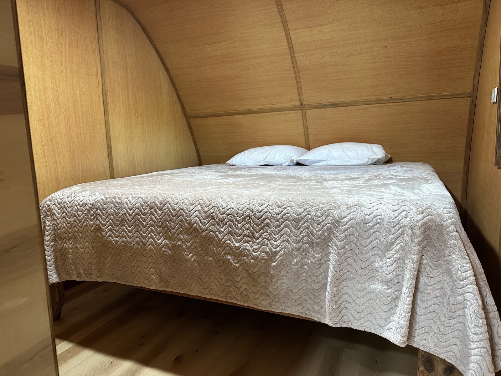 Cozy queen bed in Casa Bambú beneath a curved wood-paneled ceiling