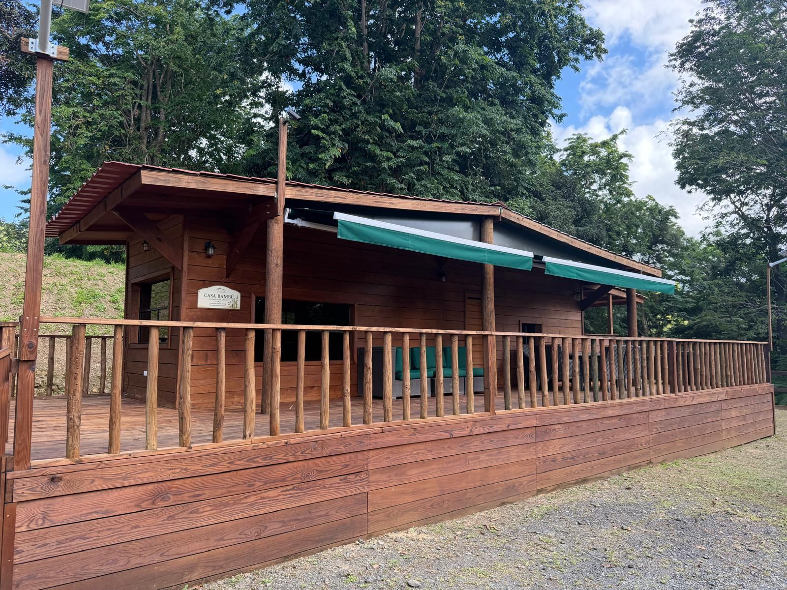 Casa Bambú with its wraparound deck and green awnings at Hacienda Yuké